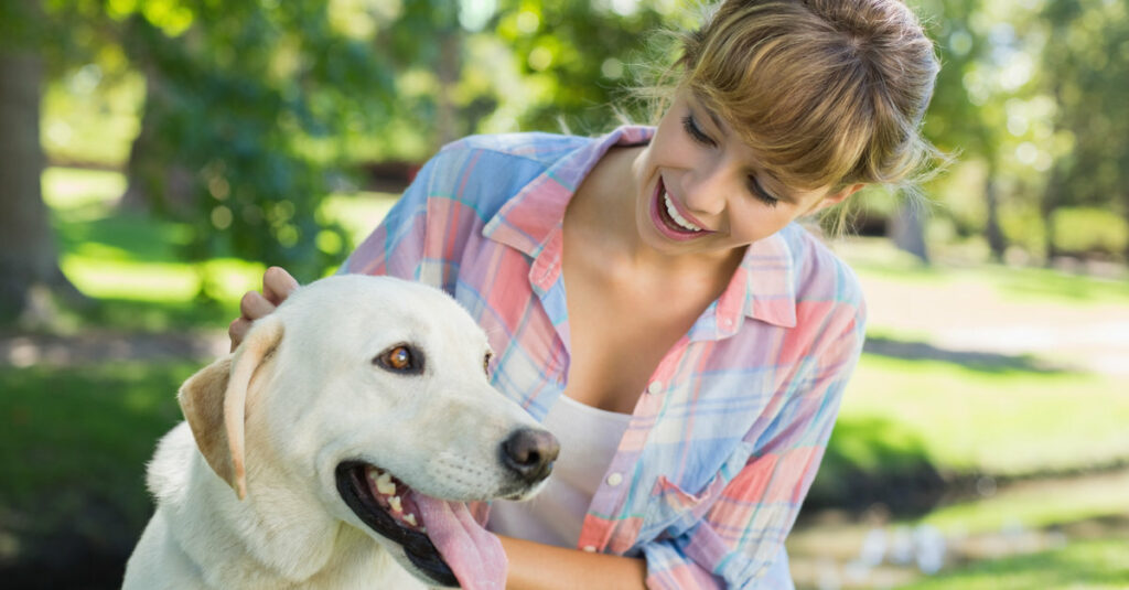 blonde-woman-petting-labrador-trained-companion-dog-1024x535
